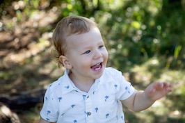 Kleinkind, das lächelnd seinen Arm ausstreckt