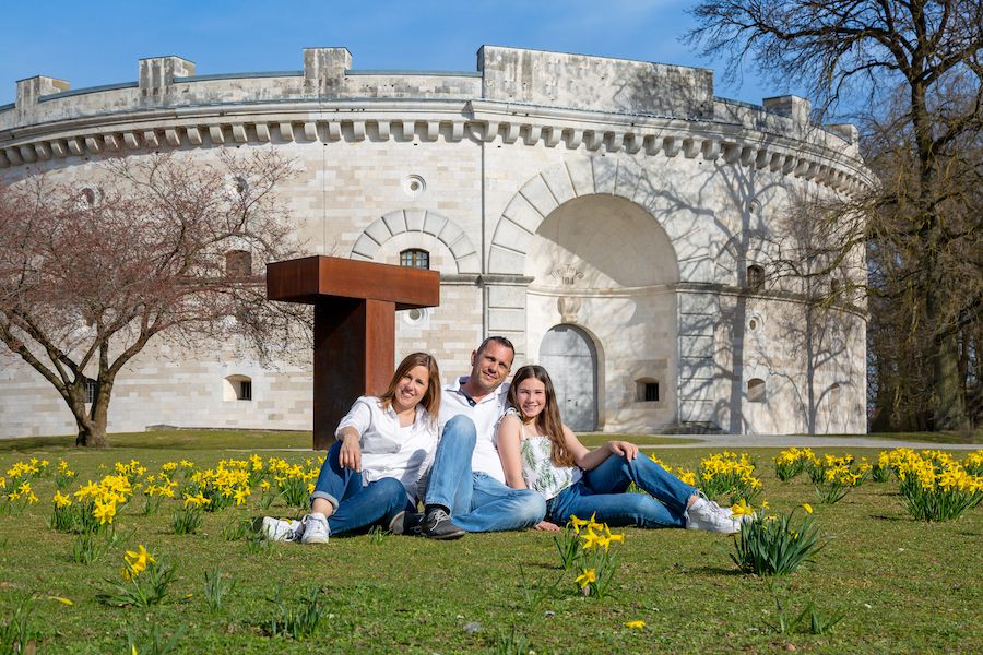 Familie auf einer Wiese vor einem historischen Festungsbau